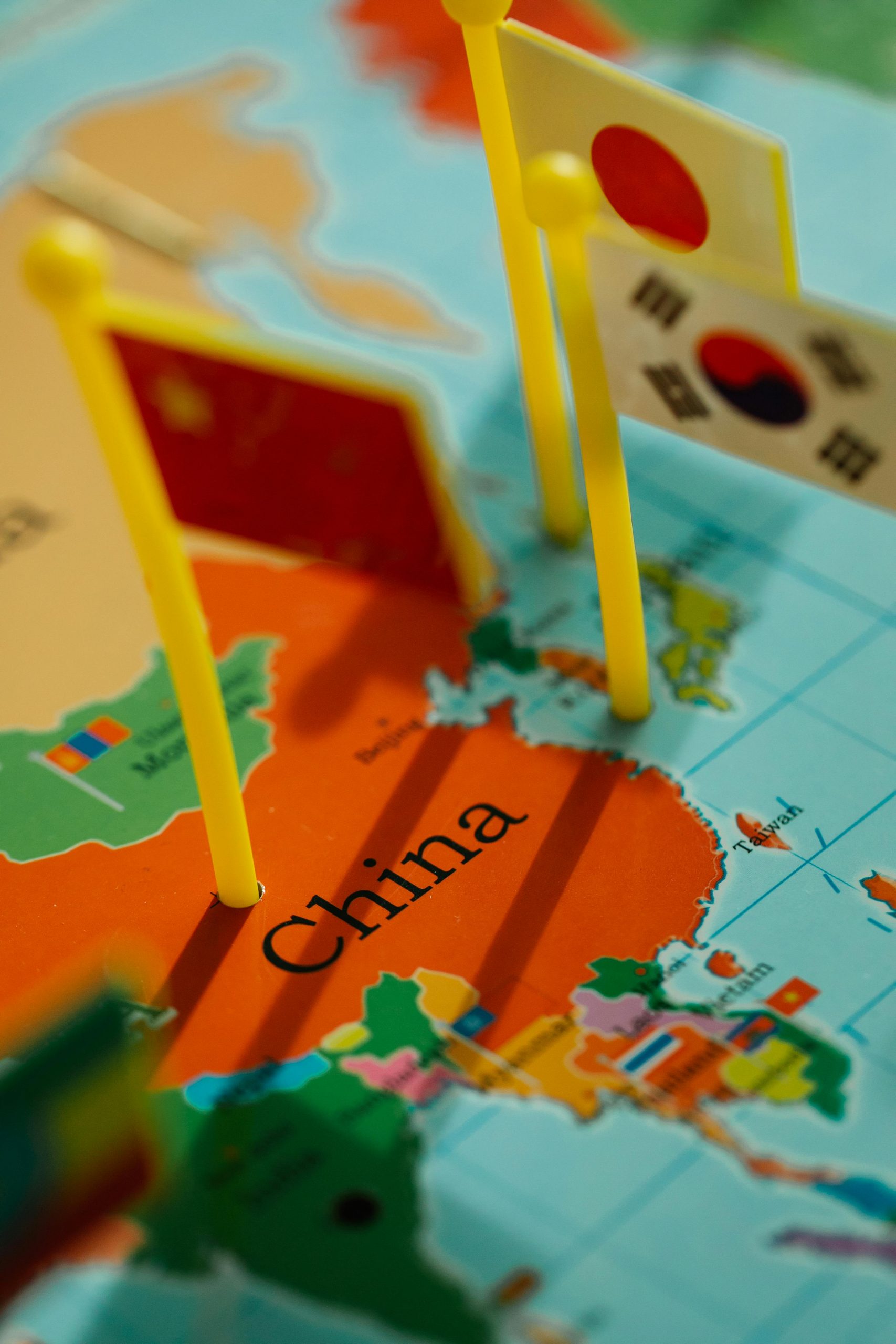 Flags representing Asian countries on a detailed map of China. Vibrant colors and focus on China.